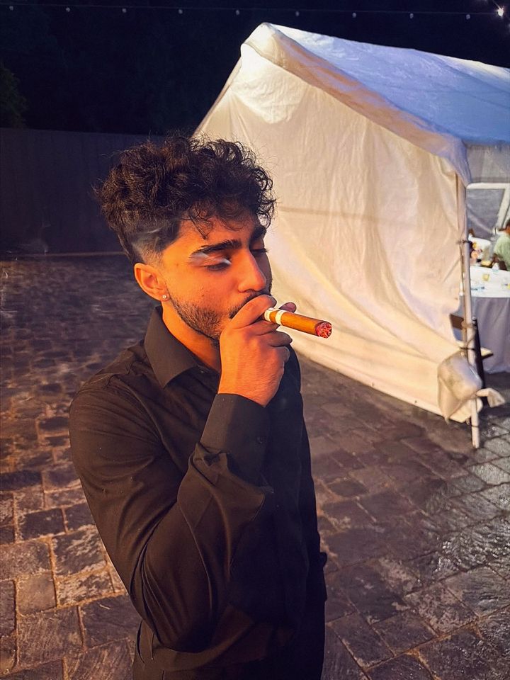 YNGM0M0 smoking a cigar at night